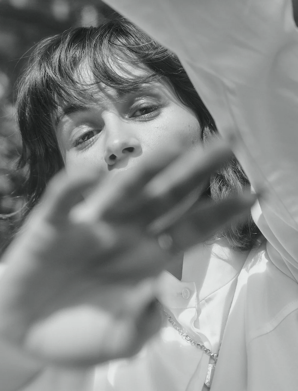 Mogli with a hand in front of her face behind sheer fabric, black and white, styling Anita Bauer