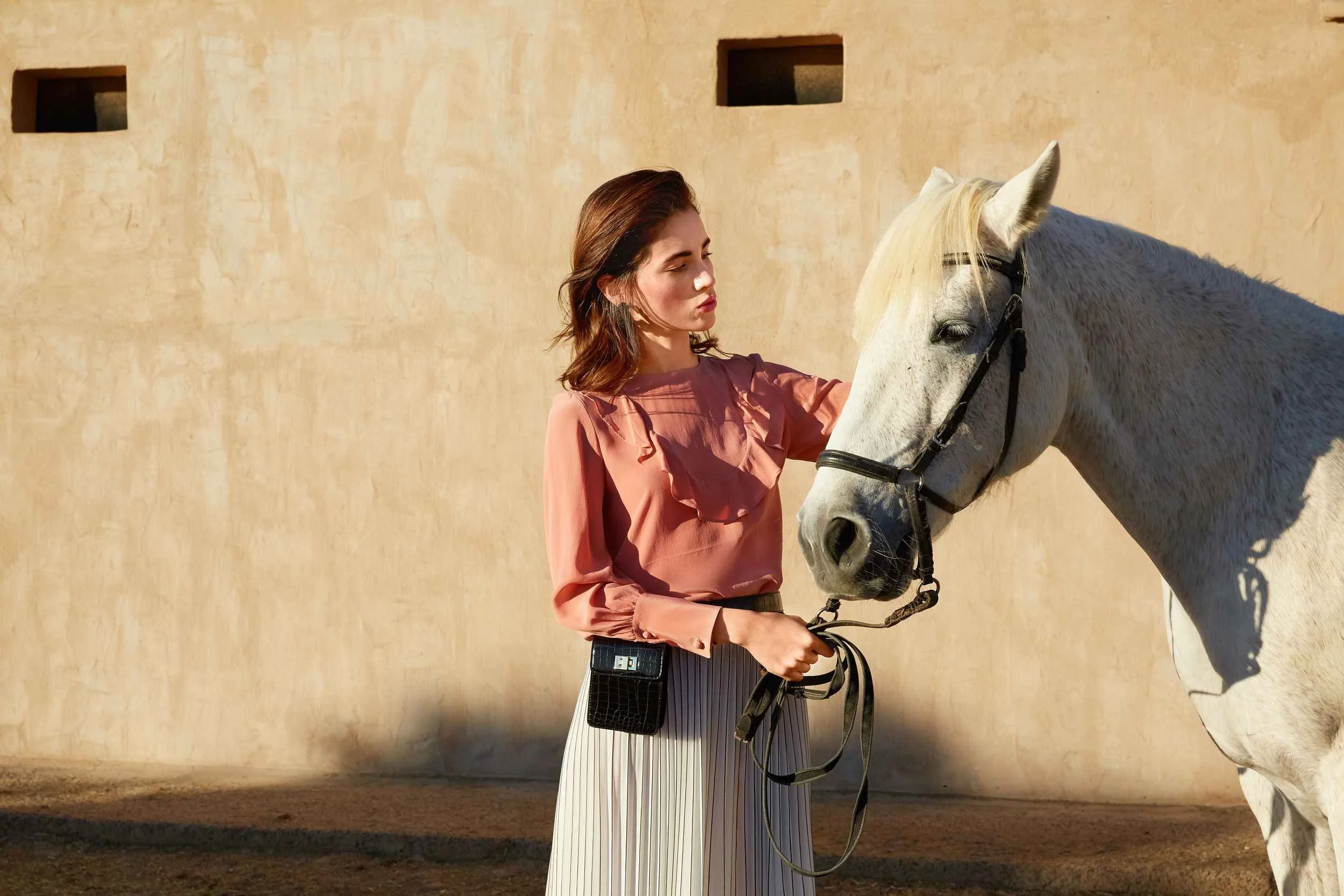 Pink blouse and pleated skirt with a white horse
