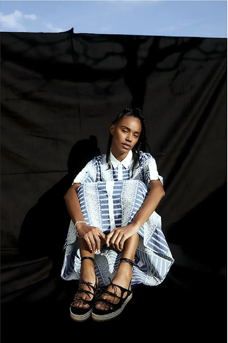 Blue checked dress in front of a black backdrop outdoors