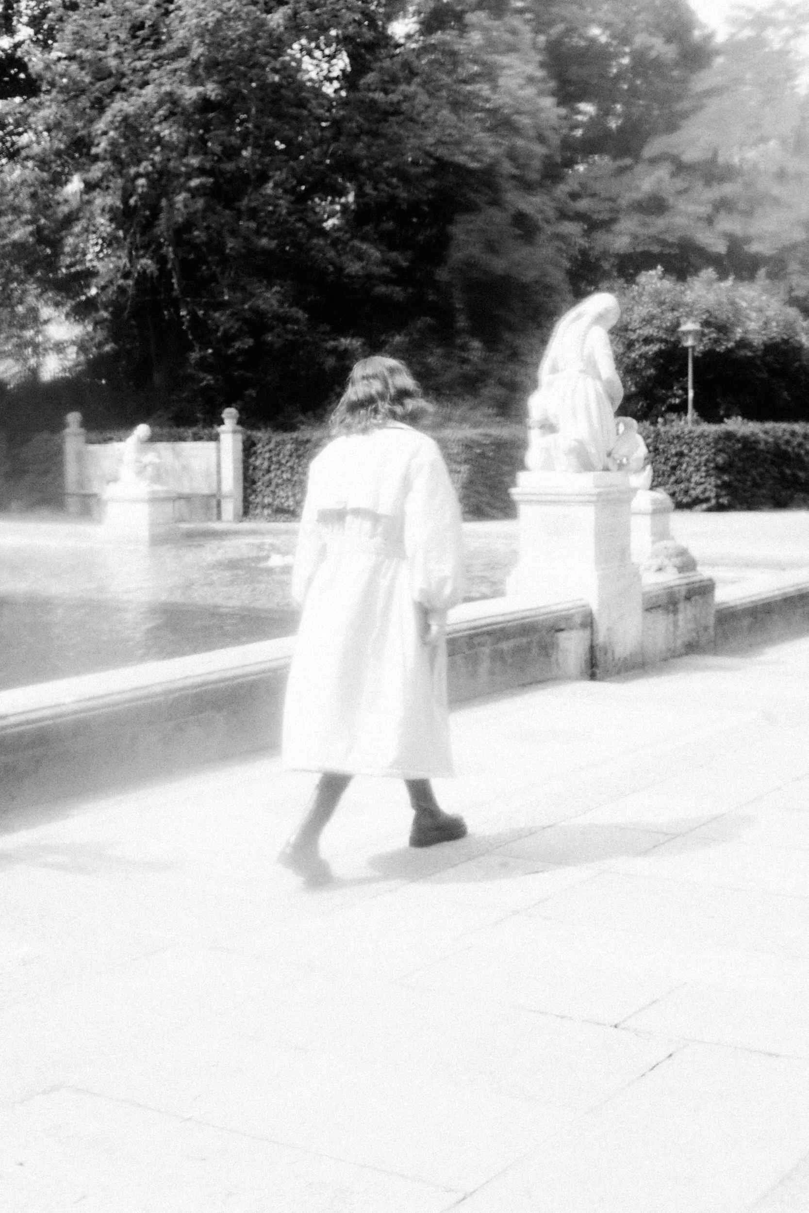 Mogli walking away in a white coat, black and white