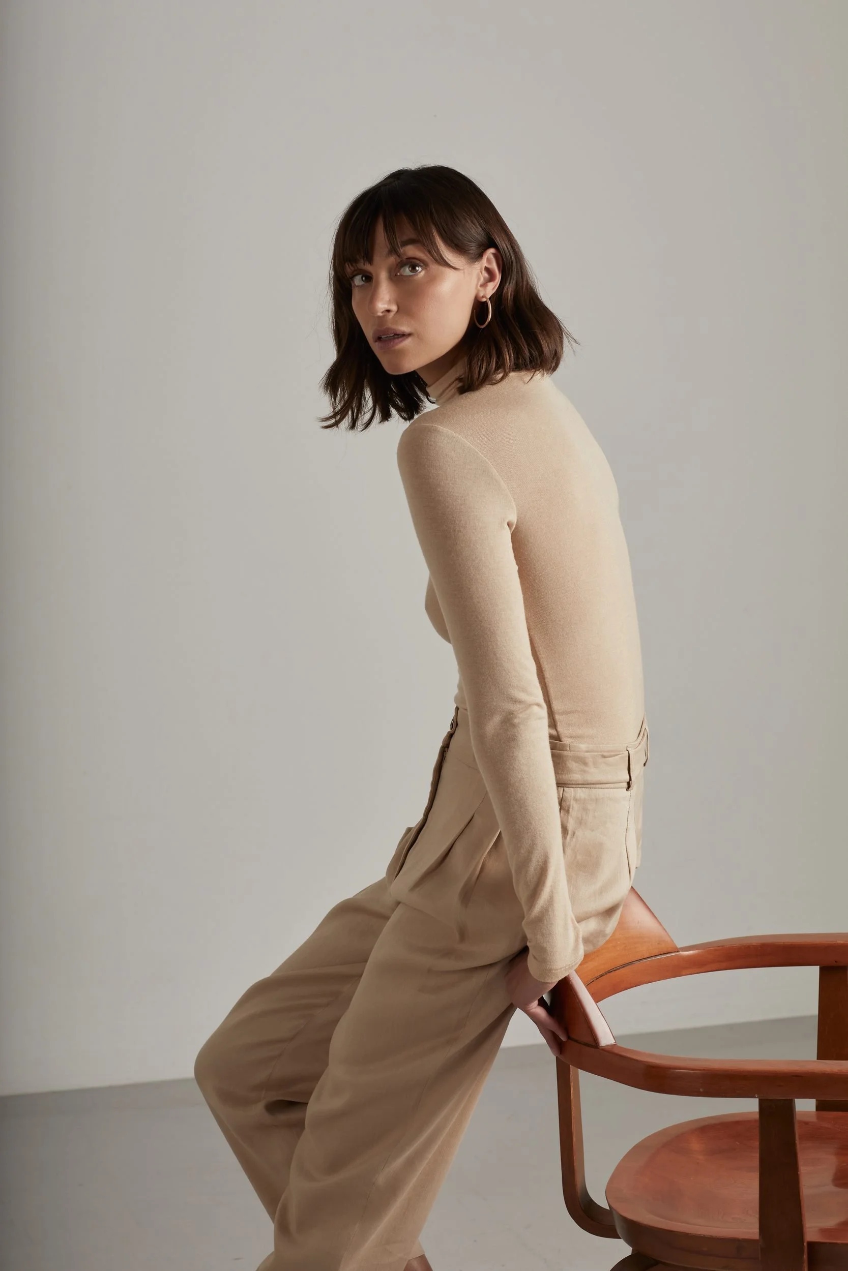 Jewellery campaign for Sian Design: beige knit and trousers beside a wooden chair
