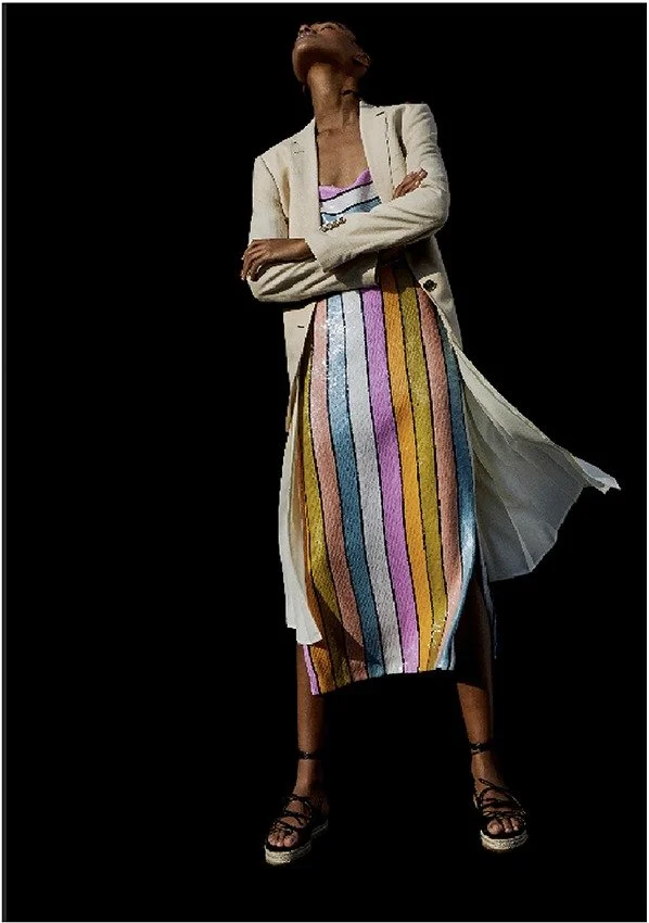 Striped dress with a blazer against a black backdrop