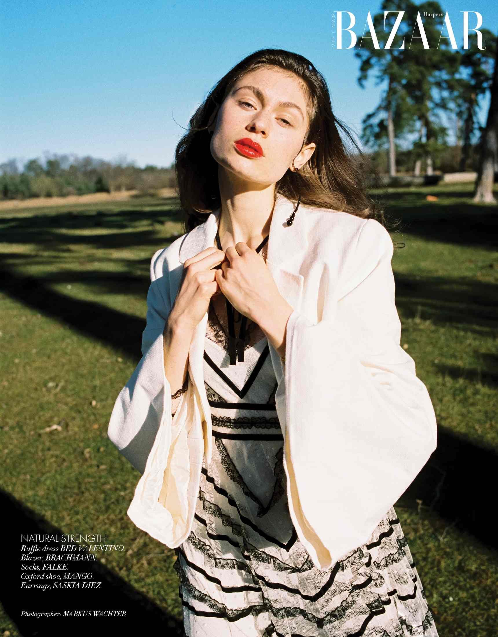 Harper's Bazaar Vietnam editorial: white blazer over a graphic printed dress in sunlight