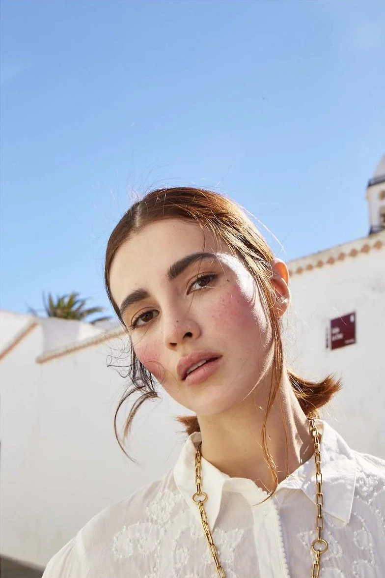 Portrait in a white lace blouse with a chain necklace