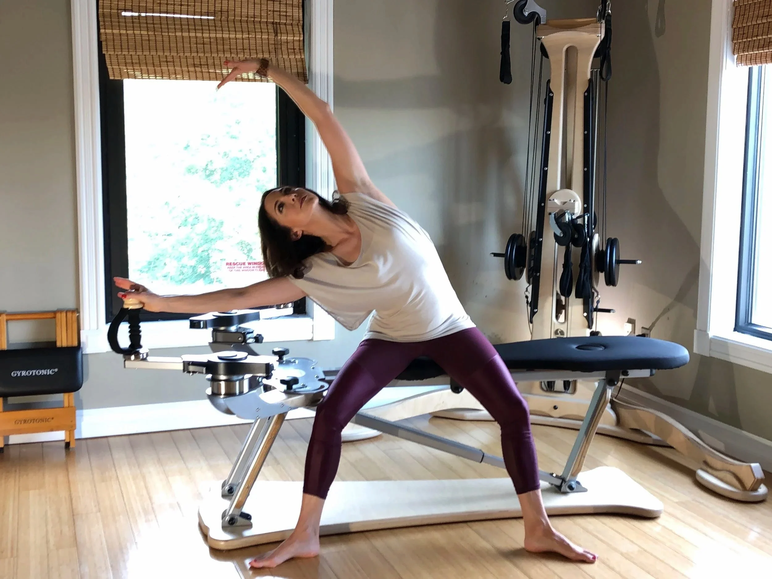 Kerri Affronti performing a side bending movement using the GYROTONIC® method in her Henderson, Nevada studio, emphasizing spinal mobility, strength, and coordinated full body movement.