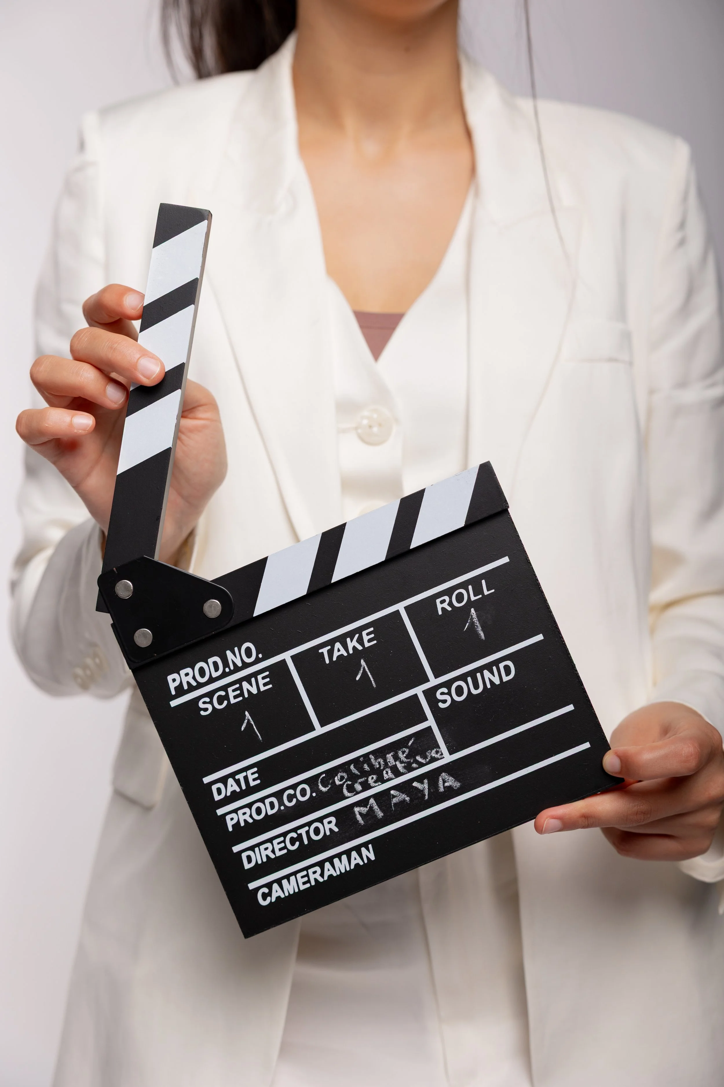 A person holding a black and white film clapperboard.