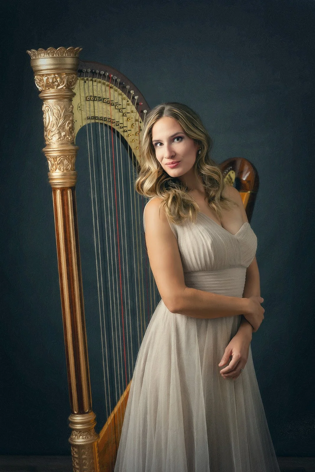 A woman with wavy blonde hair wearing a cream-colored dress, standing in front of a large wooden harp with gold accents against a dark background.