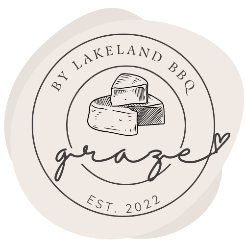 A circular label with the text 'By Lakeland BBQ' and 'Est. 2022,' featuring a sketch of cheese with three wedges.