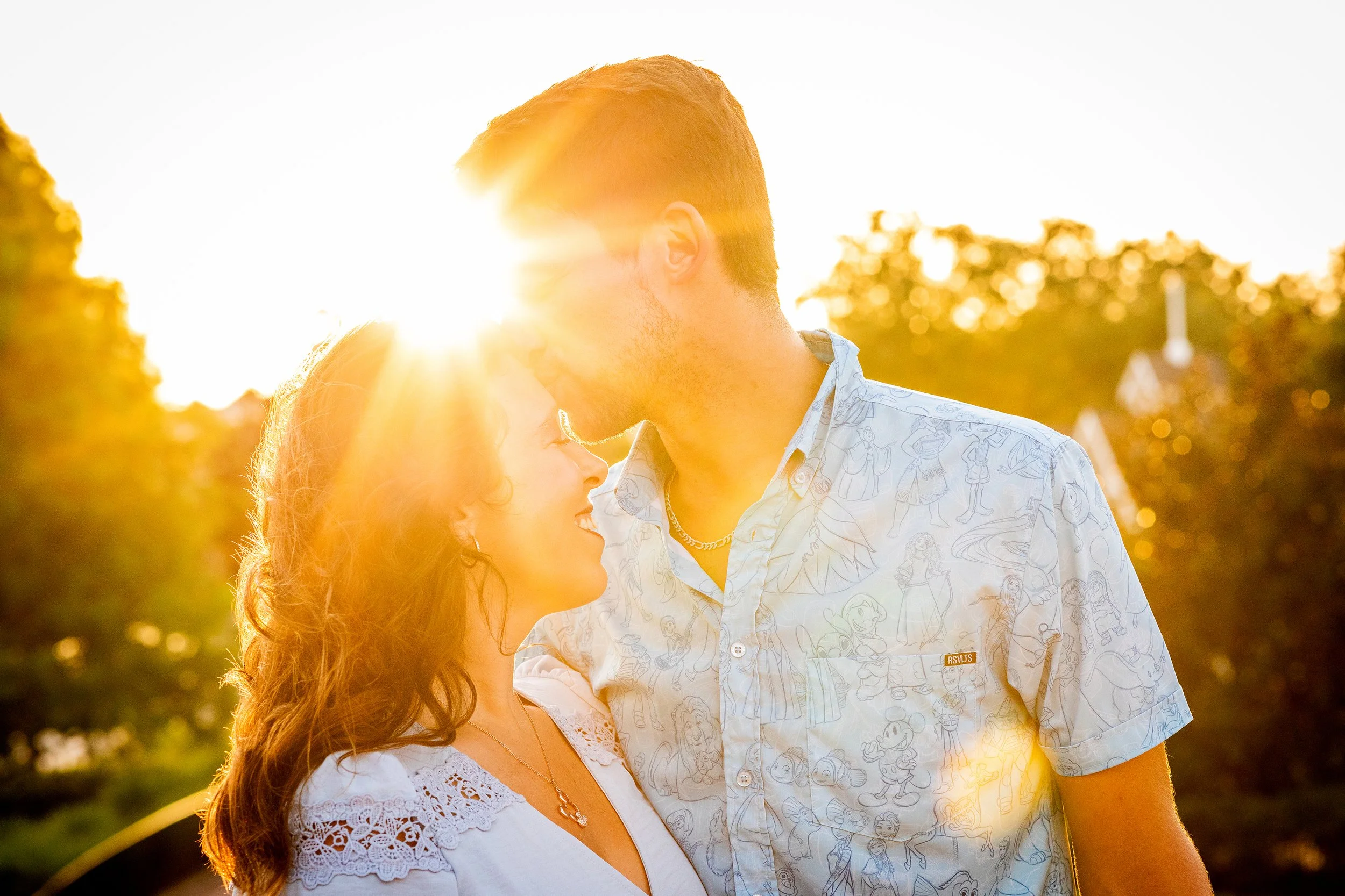 Golden hour couple photography of a couple kissing with sunlight glowing behind them