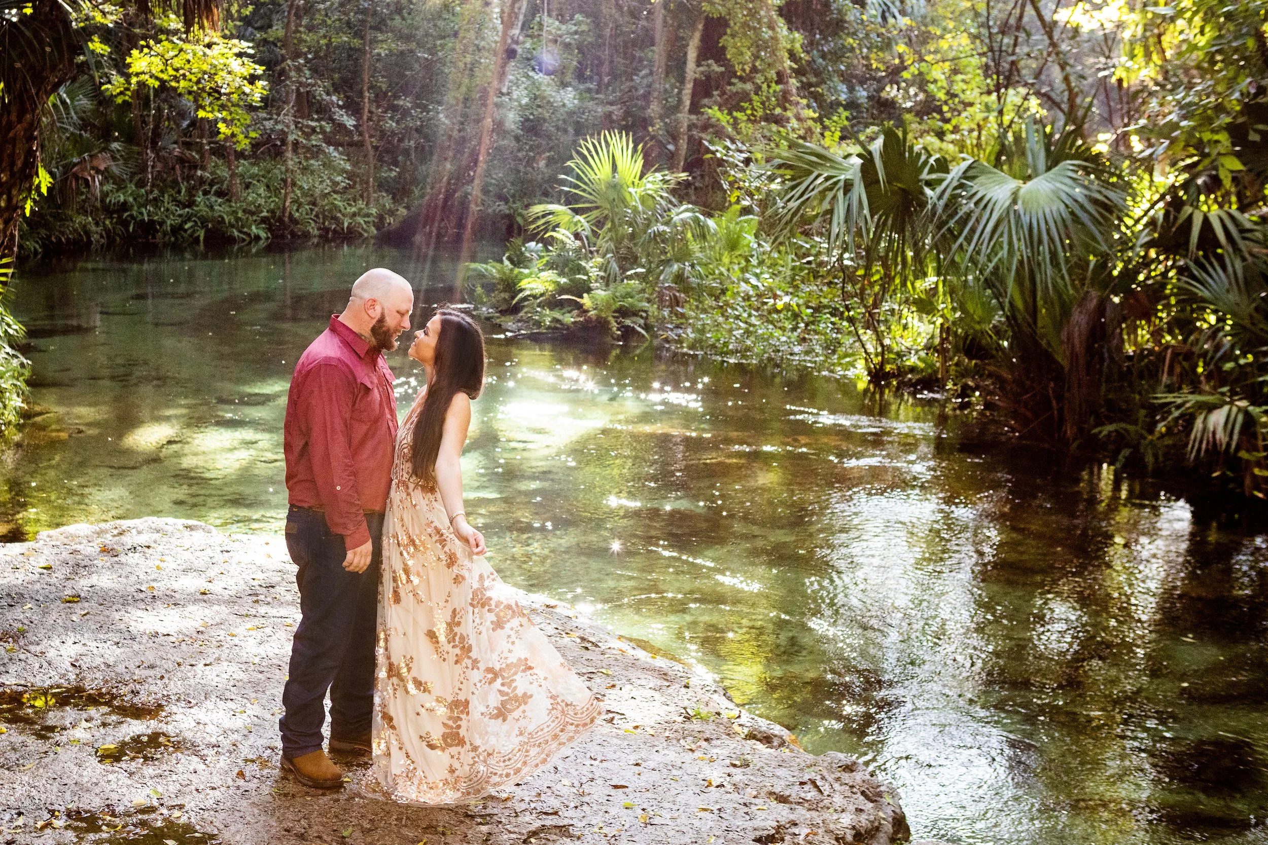 Romantic photo of a couple in Florida by a forest river with soft natural light, photographed by Lindsay Parks Photography.