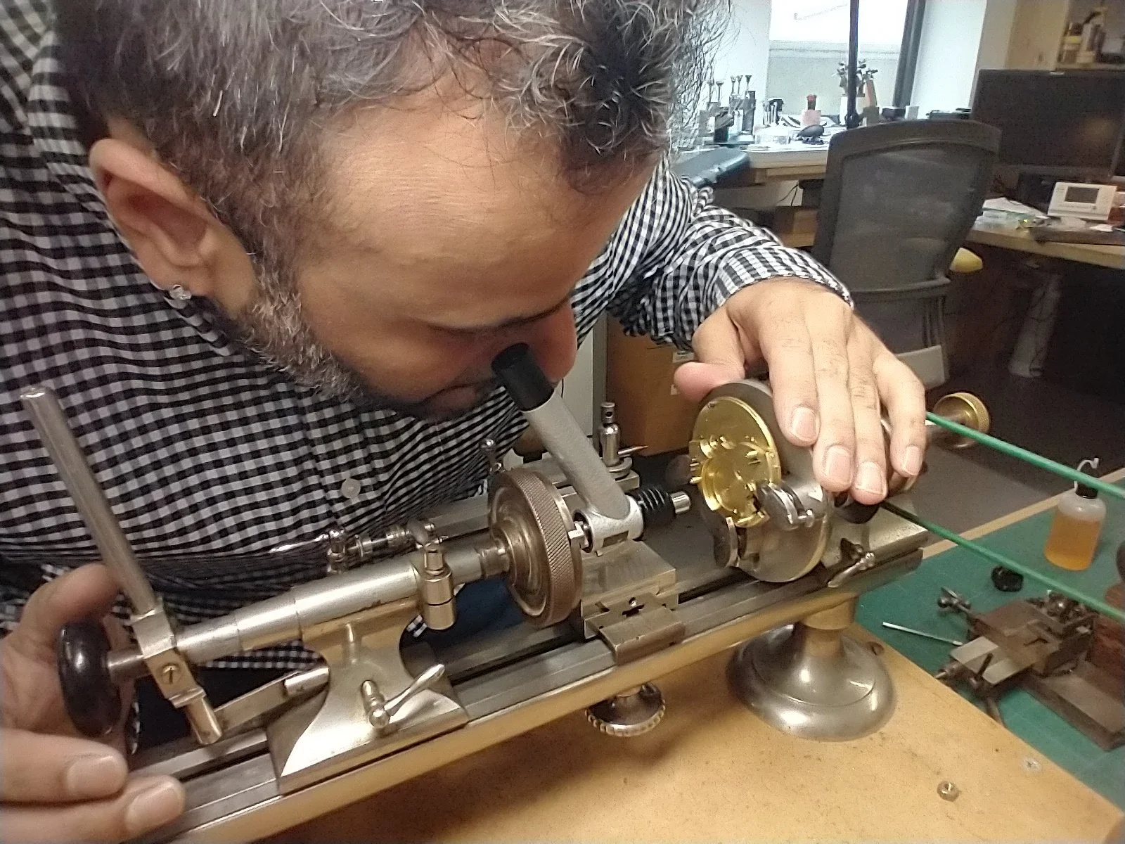 A one to one studenmt learning how to use a watchmakers lathe and centering microscope to be able to bore accurate holes in a mainplate.jpg