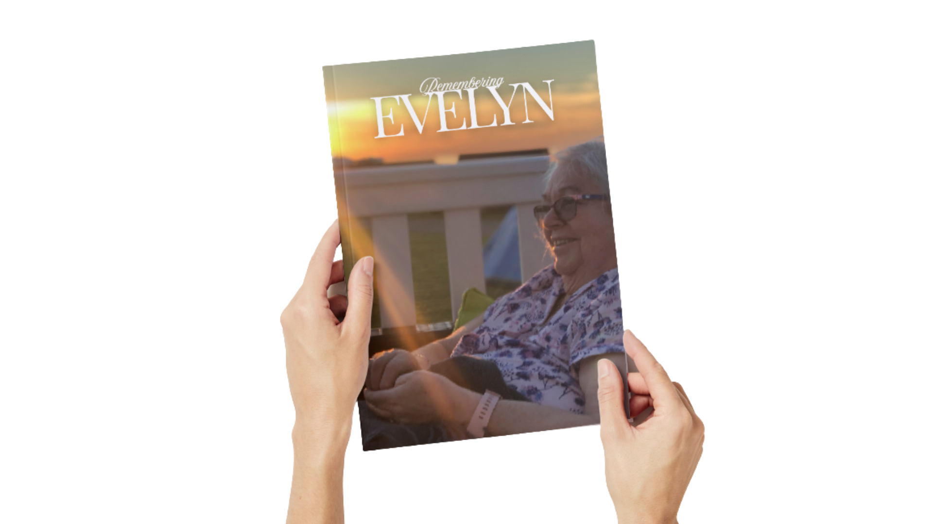 A person holding a magazine titled 'Remembering Evelyn' featuring an elderly woman with glasses sitting outside at sunset.