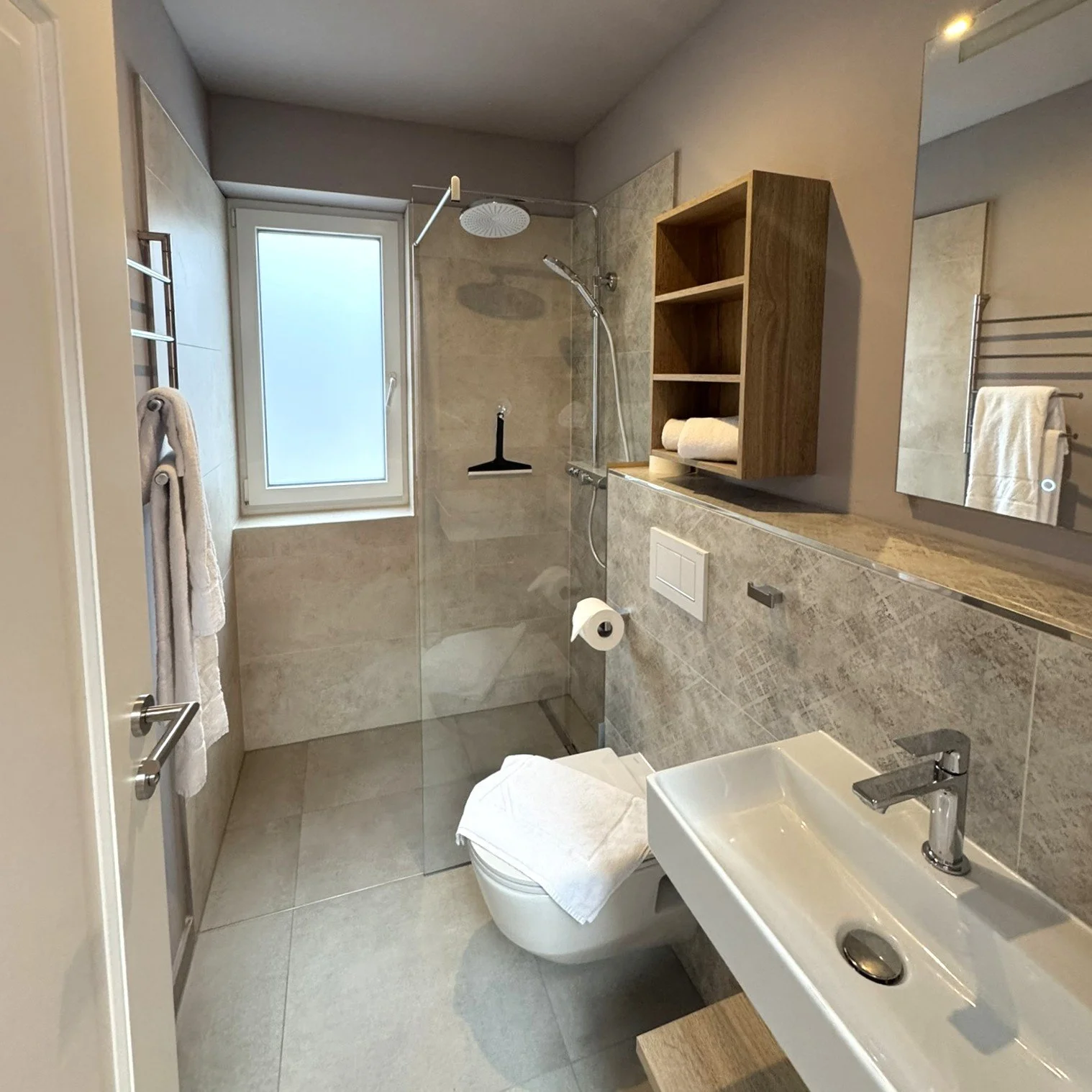 Ein modernes Badezimmer mit Dusche, WC, Waschbecken und Holzeinrichtung