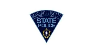 Massachusetts State Police emblem with blue triangular shape and state seal.