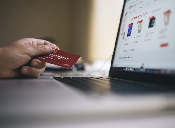 Person holding a credit card and ordering online