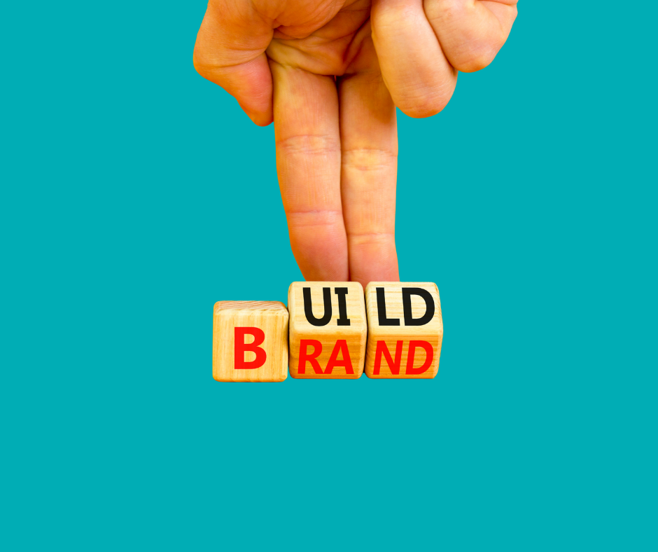 Two fingers with dices that say "build brand"