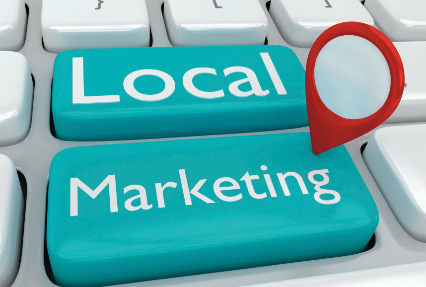 Two teal computer keys with the words "local" and "marketing" on them with a map marker