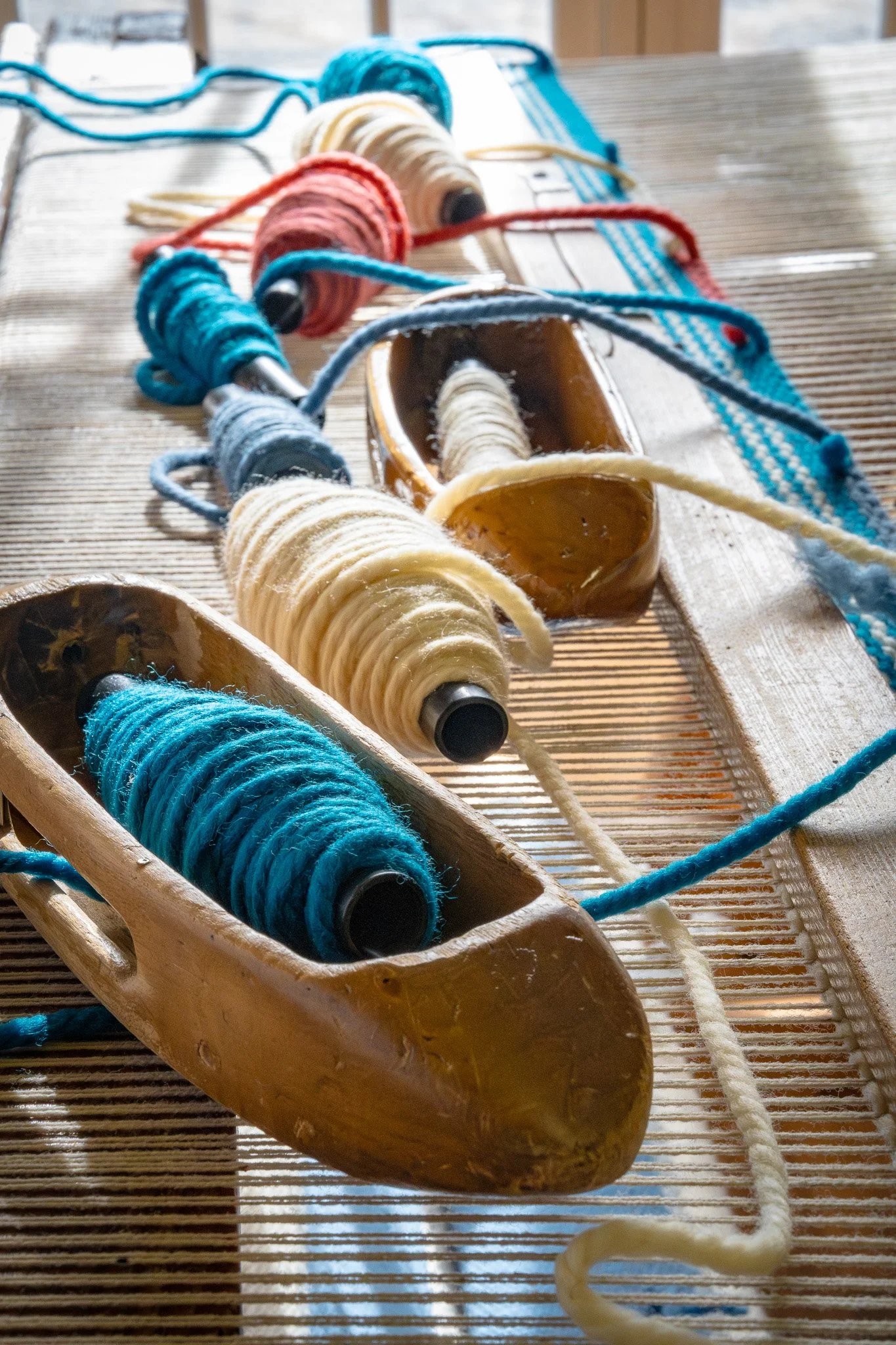 Colorful yarn spools on a wooden loom for weaving