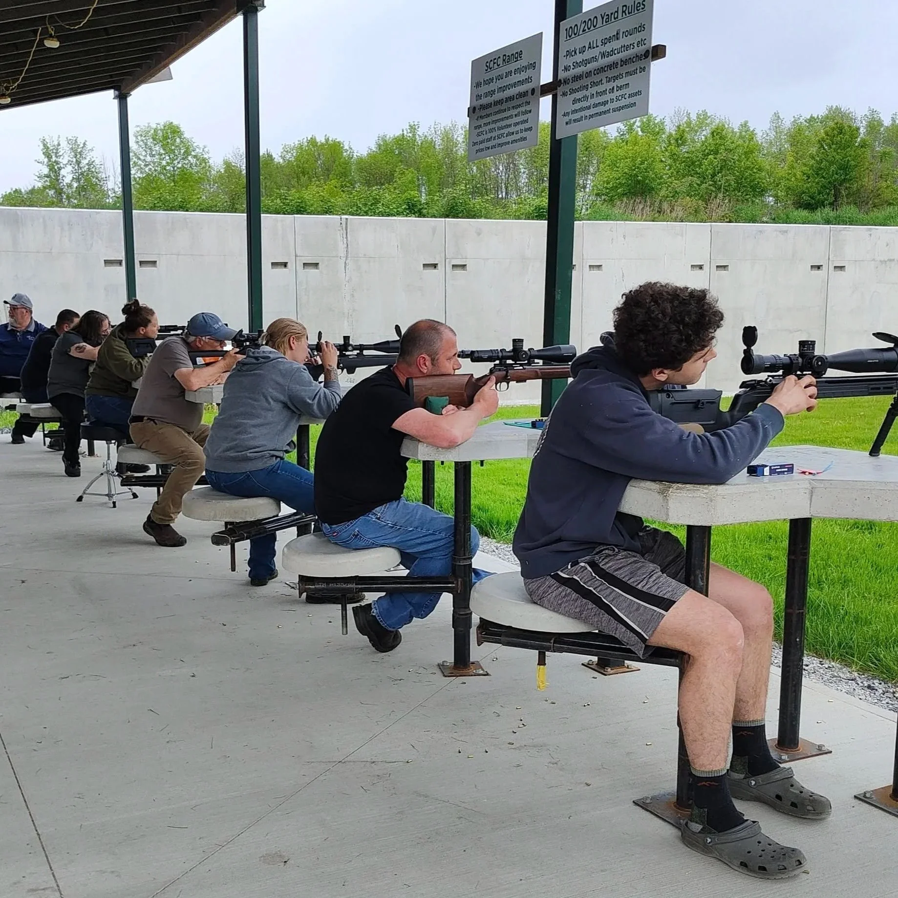People at a shooting range aiming rifles.