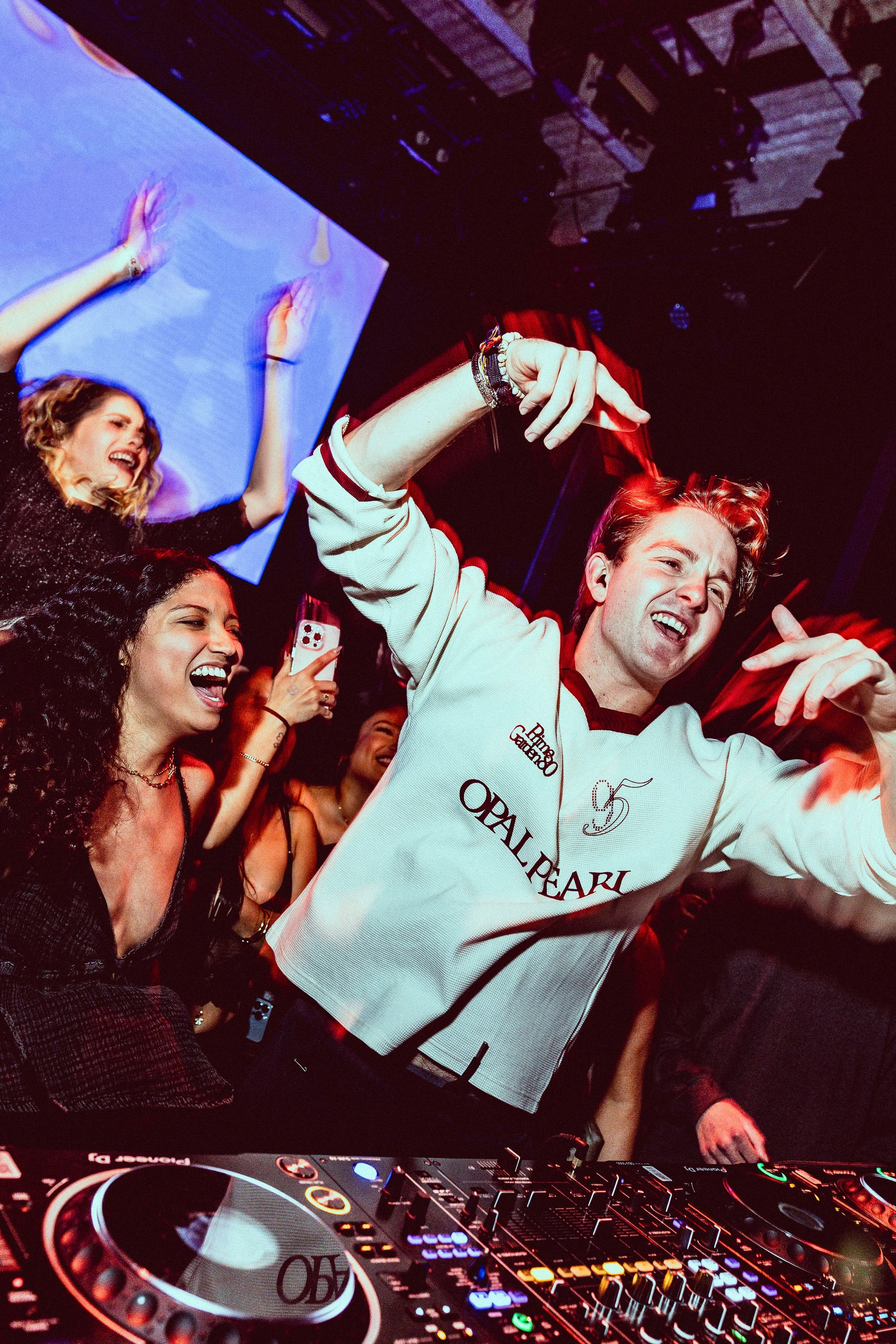 Lavern dancing and having fun at a party with a DJ and colorful lights.