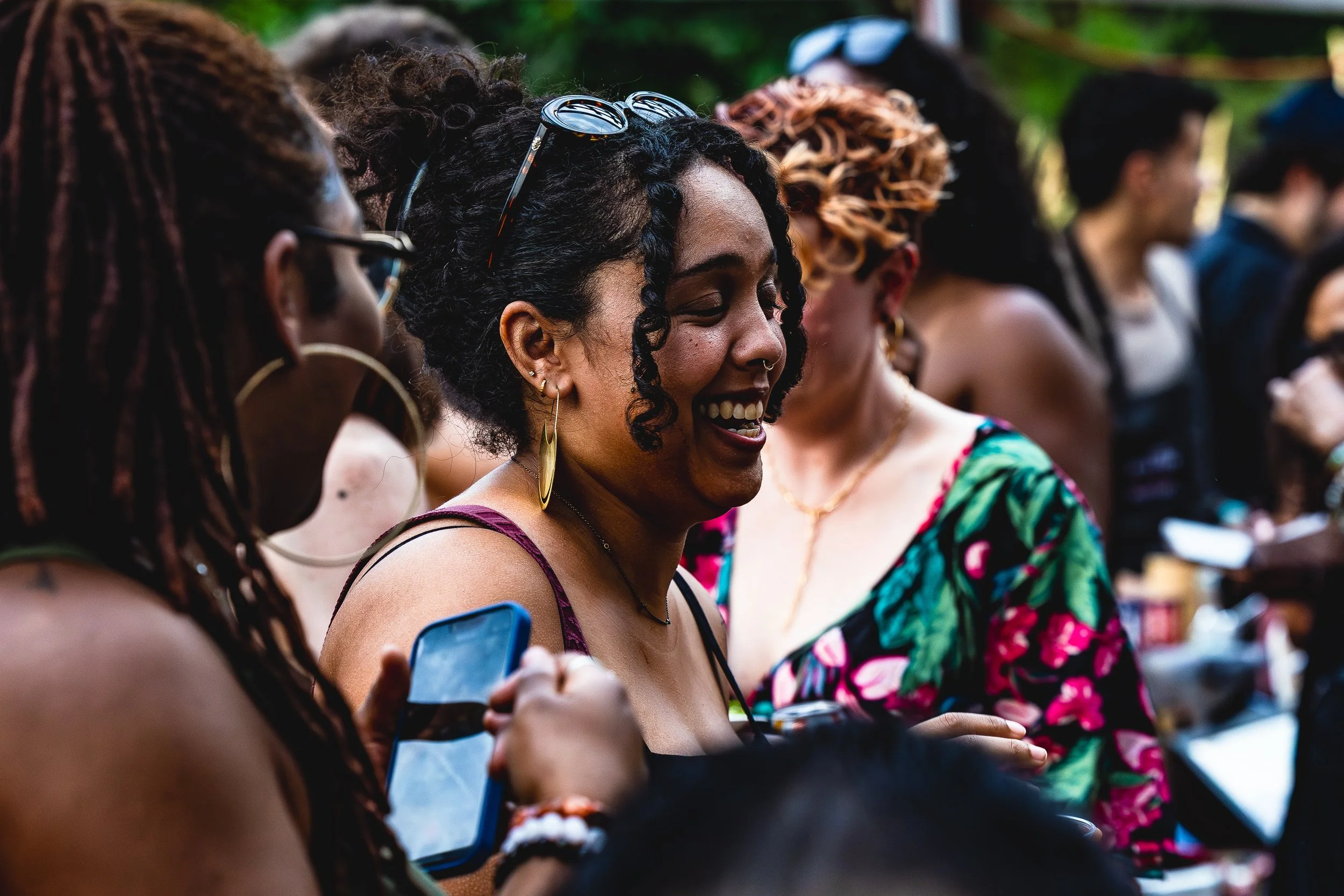Group of women socializing outdoors, smiling and enjoying each other's company.