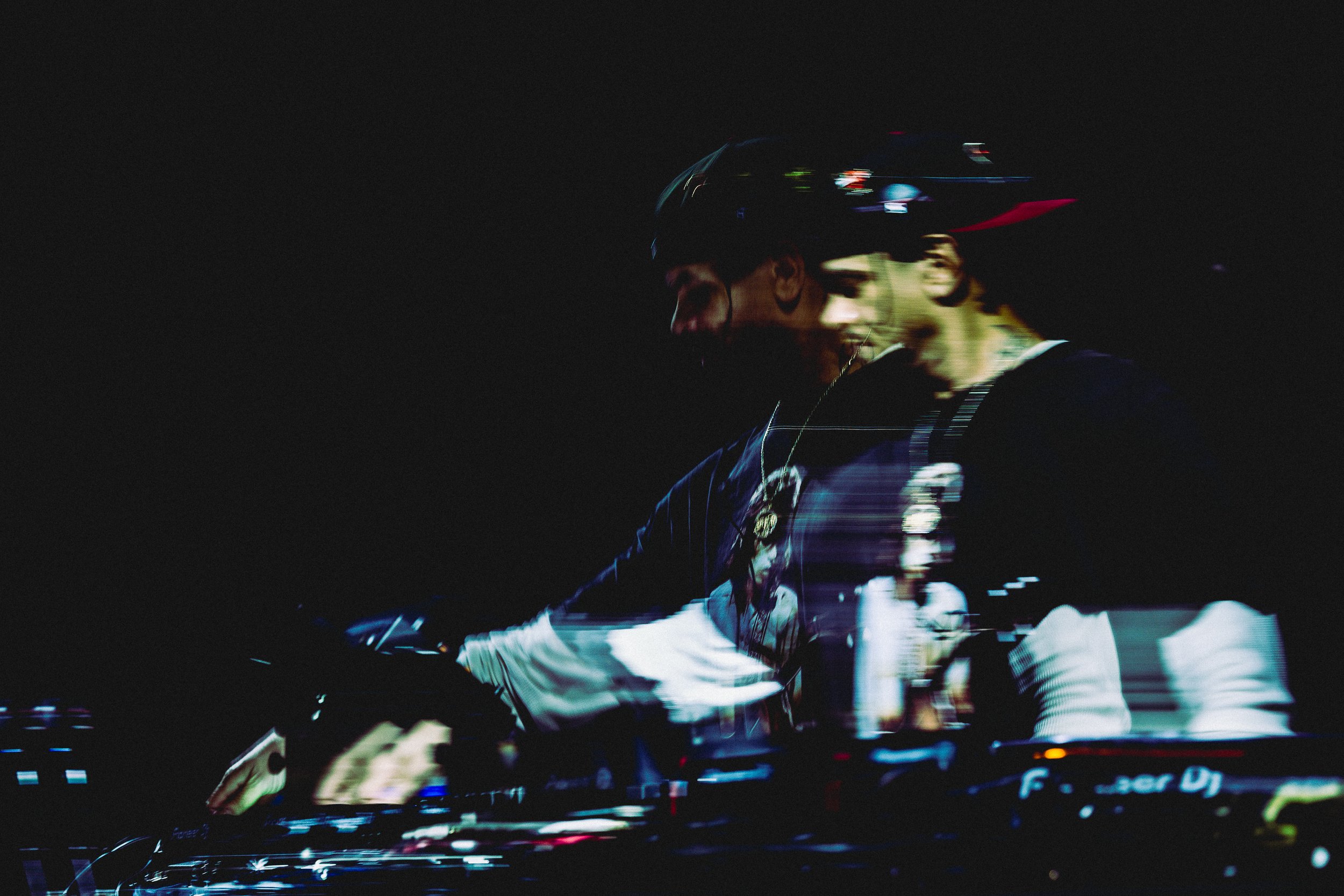 Marc Kinchen, known by his initials MK, is on stage at night with a live visual display, featuring a dark background and colorful lights.