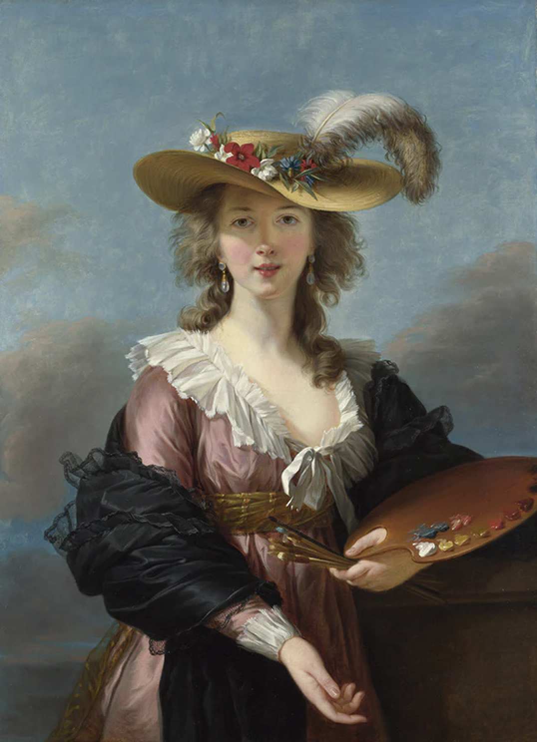 A woman wearing a large, wide-brimmed straw hat decorated with flowers and a feather, holding a painter's palette and brush, standing outdoors with a cloudy sky in the background.