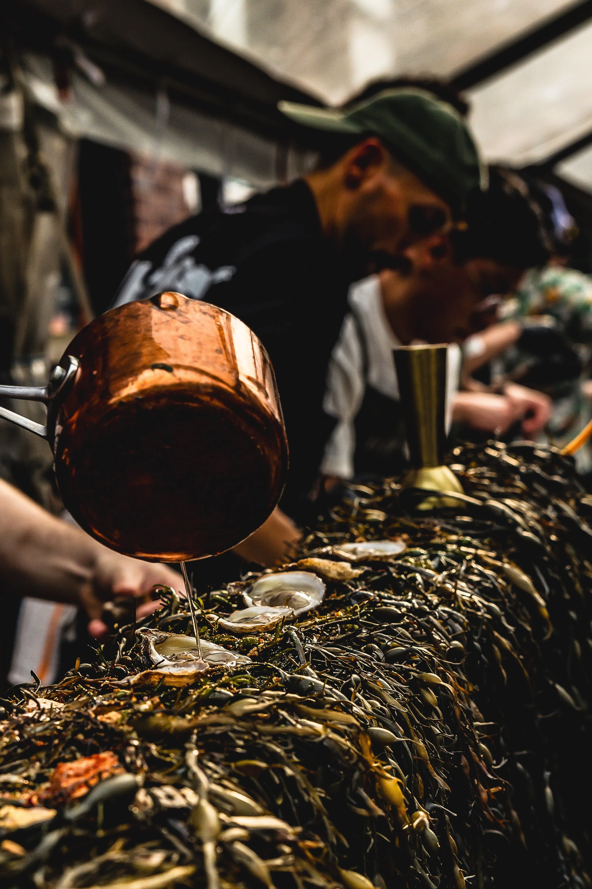 People shucking oysters at a seafood event.