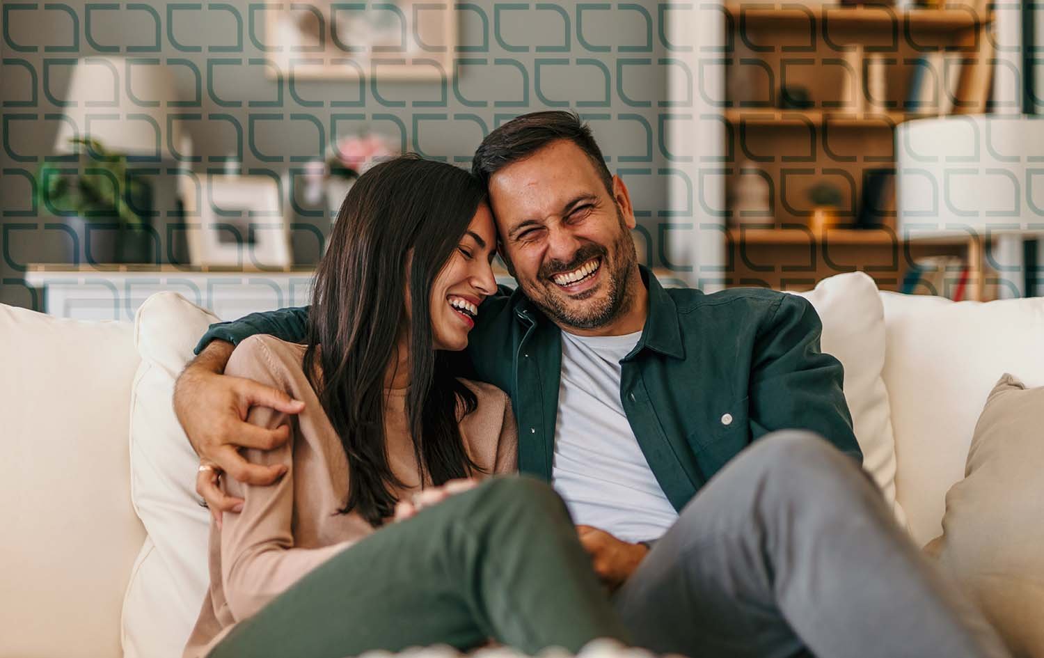 A man and woman sitting on a white couch, sharing a happy moment because of their debt recycling in Sydney.