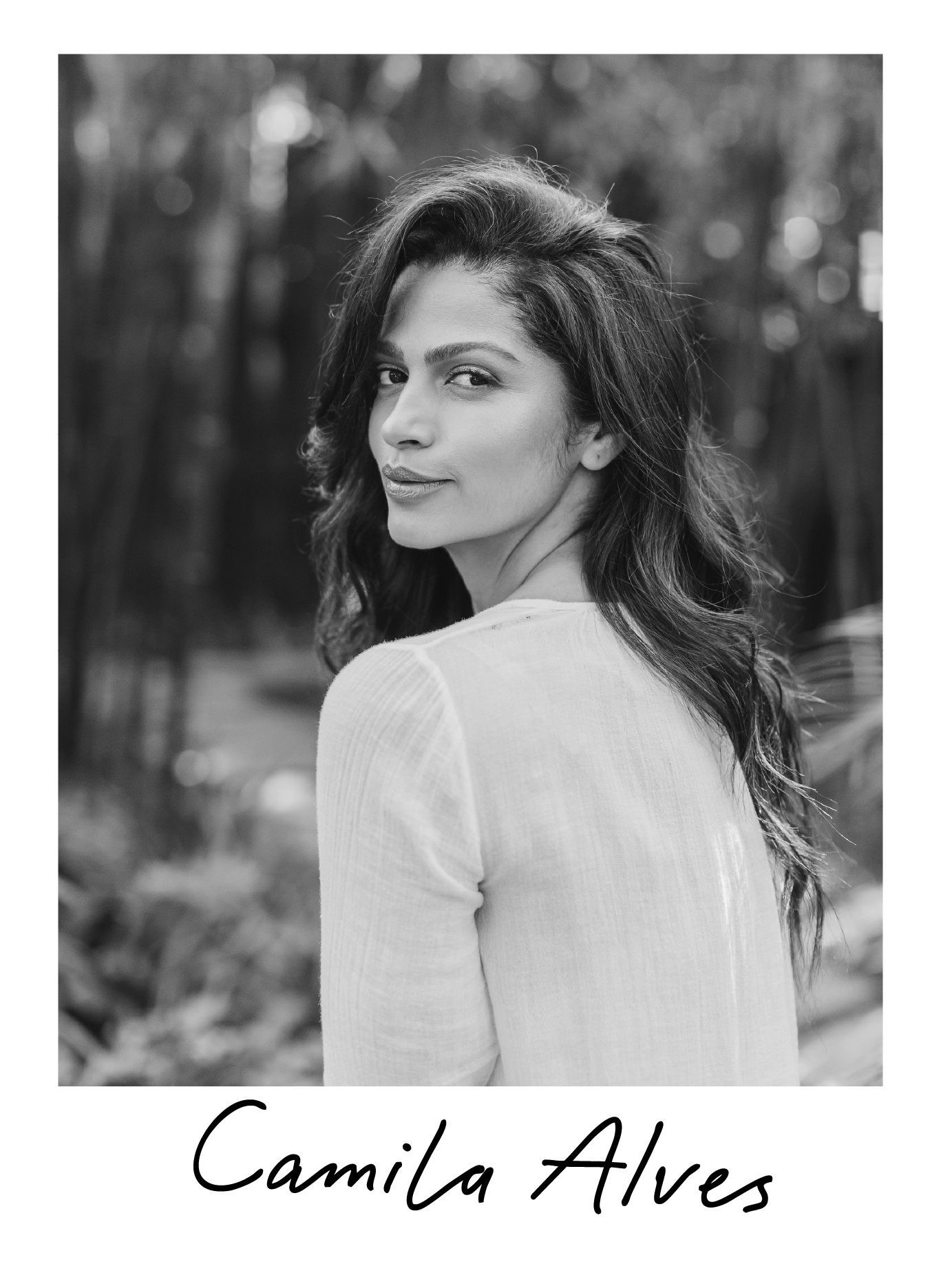 Black and white portrait of a woman with long, wavy hair, looking over her shoulder with a subtle smile, outdoors with blurred trees in the background. The name Camila Alves is written below the photo.