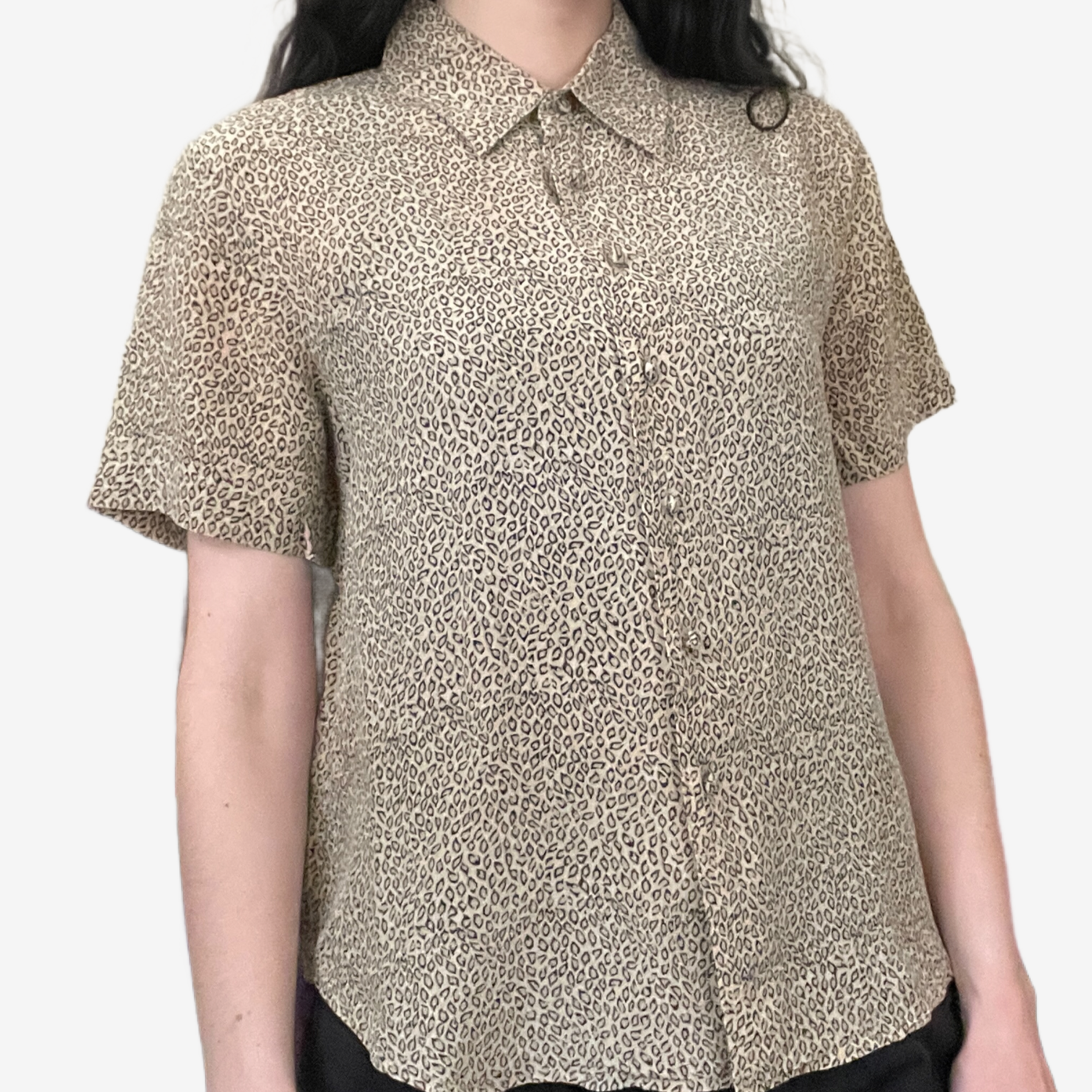 Close-up of a woman wearing a short-sleeved button-up shirt with a leopard print pattern.