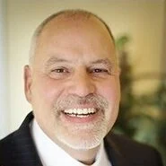 Smiling older man in a suit with a beard and mustache