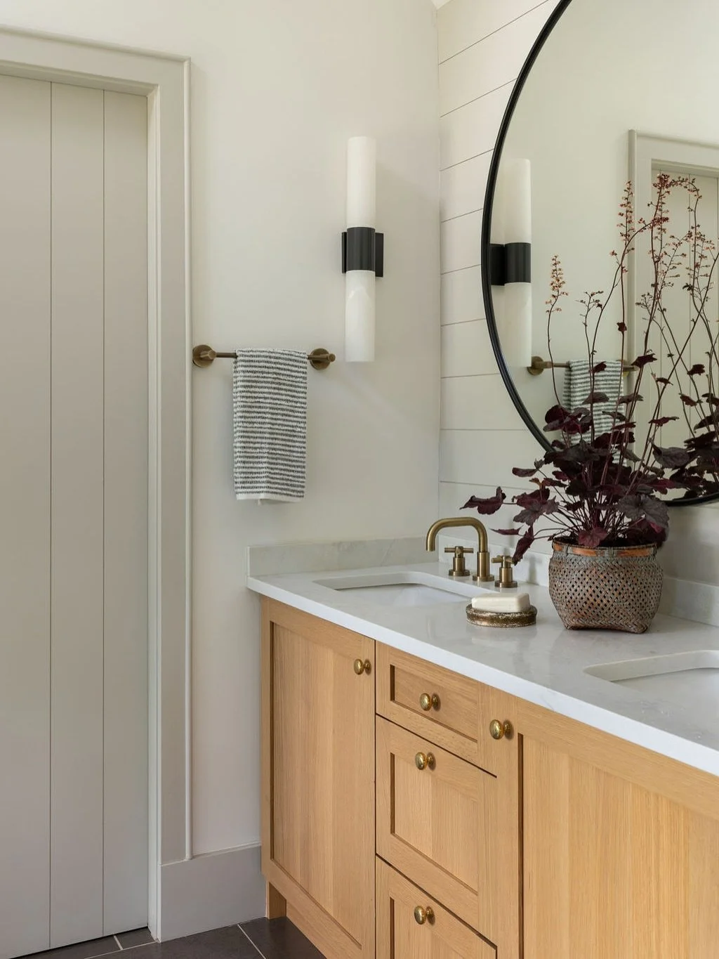 Cottage Bathroom / Casual and simple this main bedroom&rsquo;s en suite was designed to focus views out to the lake which is framed through two large windows positioned at the tub. White oak cabinetry, ceramic and limestone tiles complete the restful