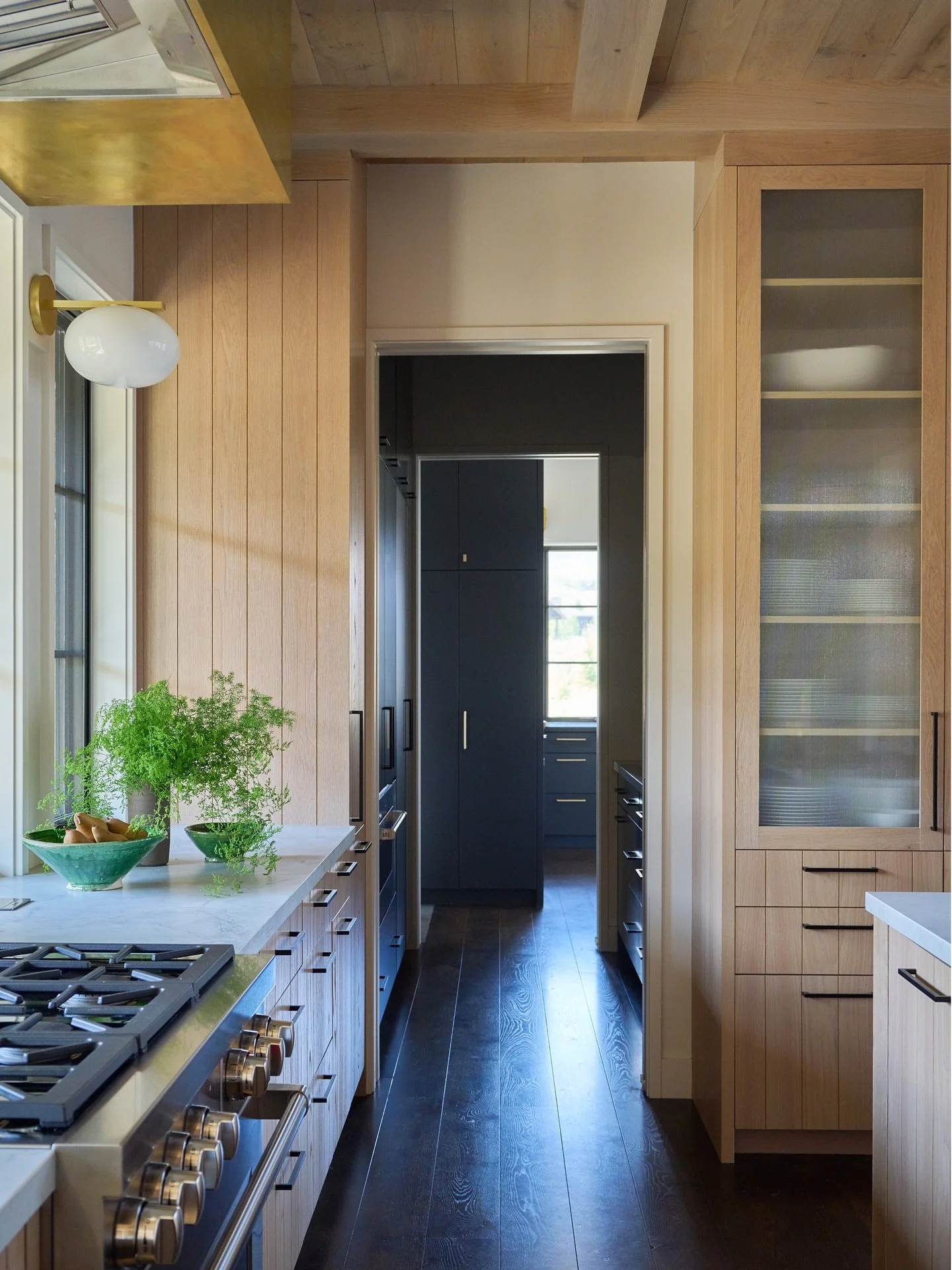 Connection / A working pantry connects this light filled kitchen back to the rear entry and garage as well as a bar built for entertaining. A mix of wood, brass and reeded glass bring texture and connect the home to its rugged landscape. #designenmas
