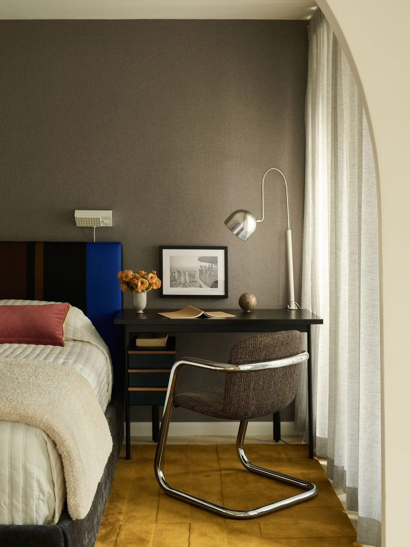 Small Space Living / This Marina City home was short on space but the client wanted a space to work from home in style. A mix of new and vintage pieces brings a collected look. A warm ochre rug sets the scene and reflects a warm light into the space.