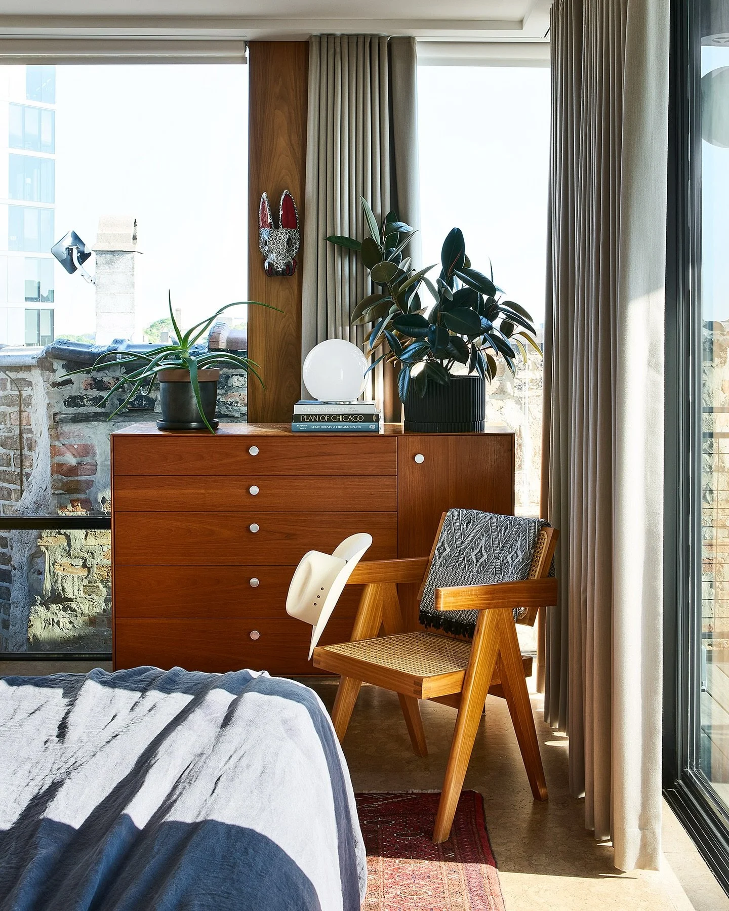 Comfort + Layers / This home set among Logan Square rooftops remains warm and layered despite its modern design and floor to ceiling windows. Vintage finds, walnut clad columns, and cork floors bring in natural textures. #designenmasse 📸 @rymcdon St