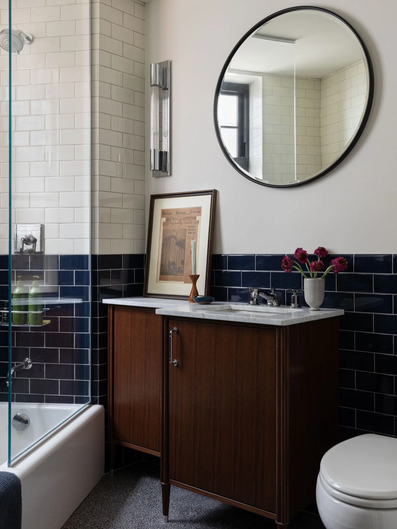 1920s bathroom refresh / Located in a classic Lake Shore Drive building this guest bath pays homage to the time period but is updated with two tone tile and terrazzo floors. A custom walnut vanity makes use of the pie shaped space and provides storag