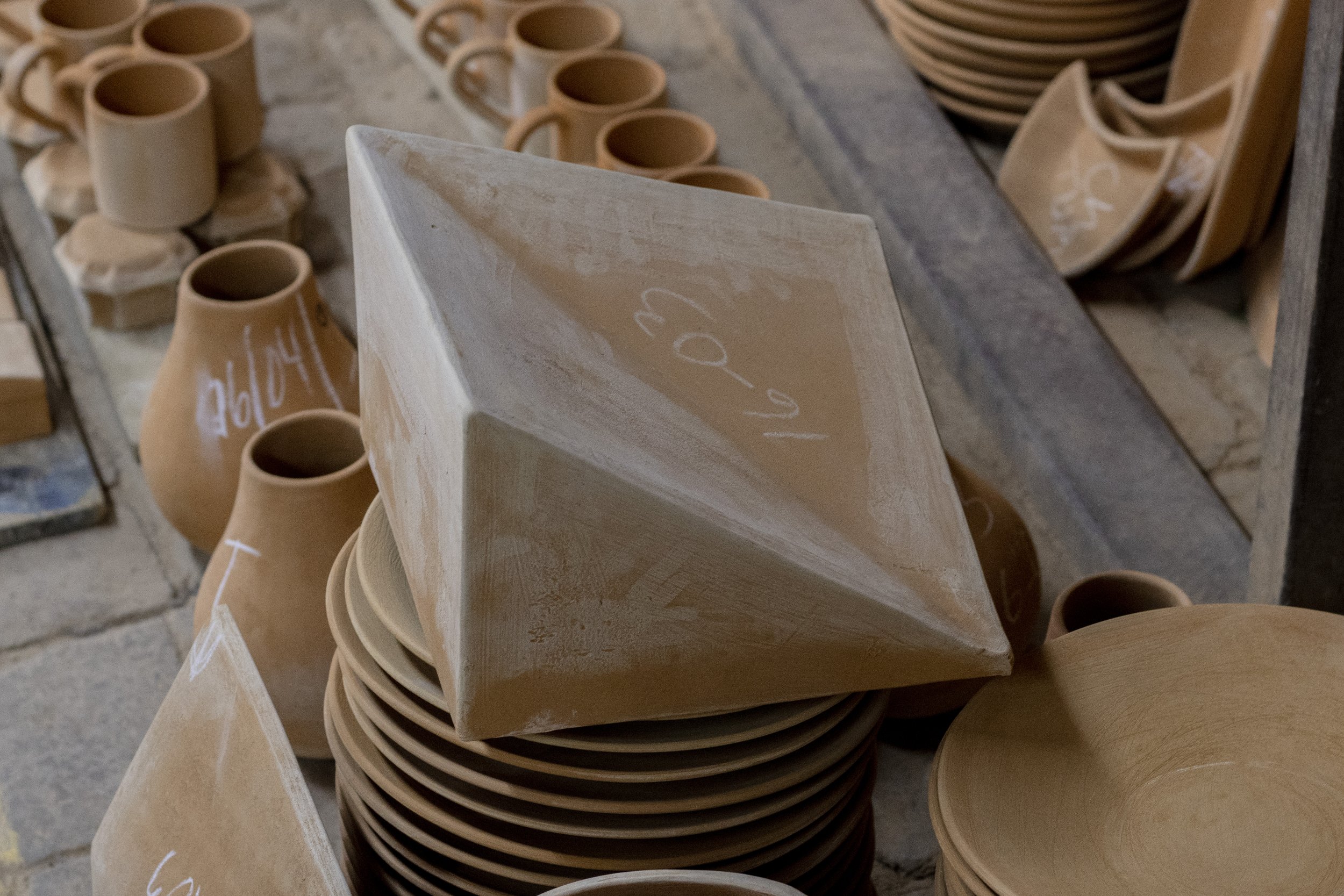 Ladrillos de cerámica y vasijas en un taller de cerámica artesanal.