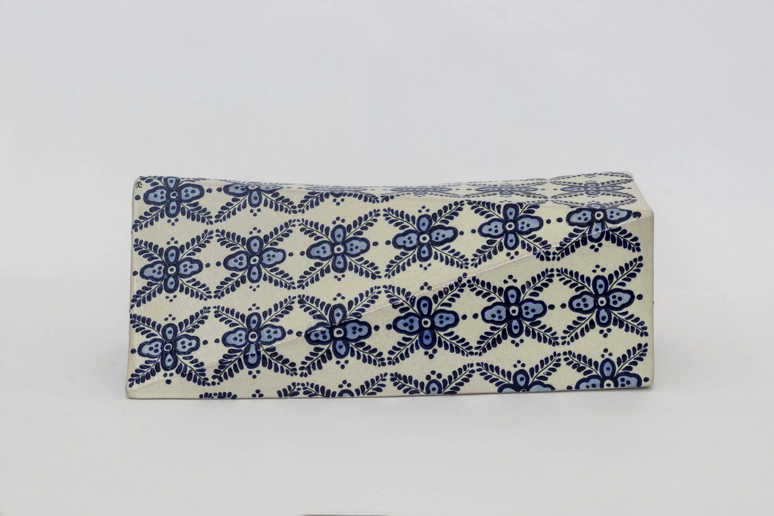 Caja rectangular decorada con patrón de flores en tonos azules sobre fondo blanco.