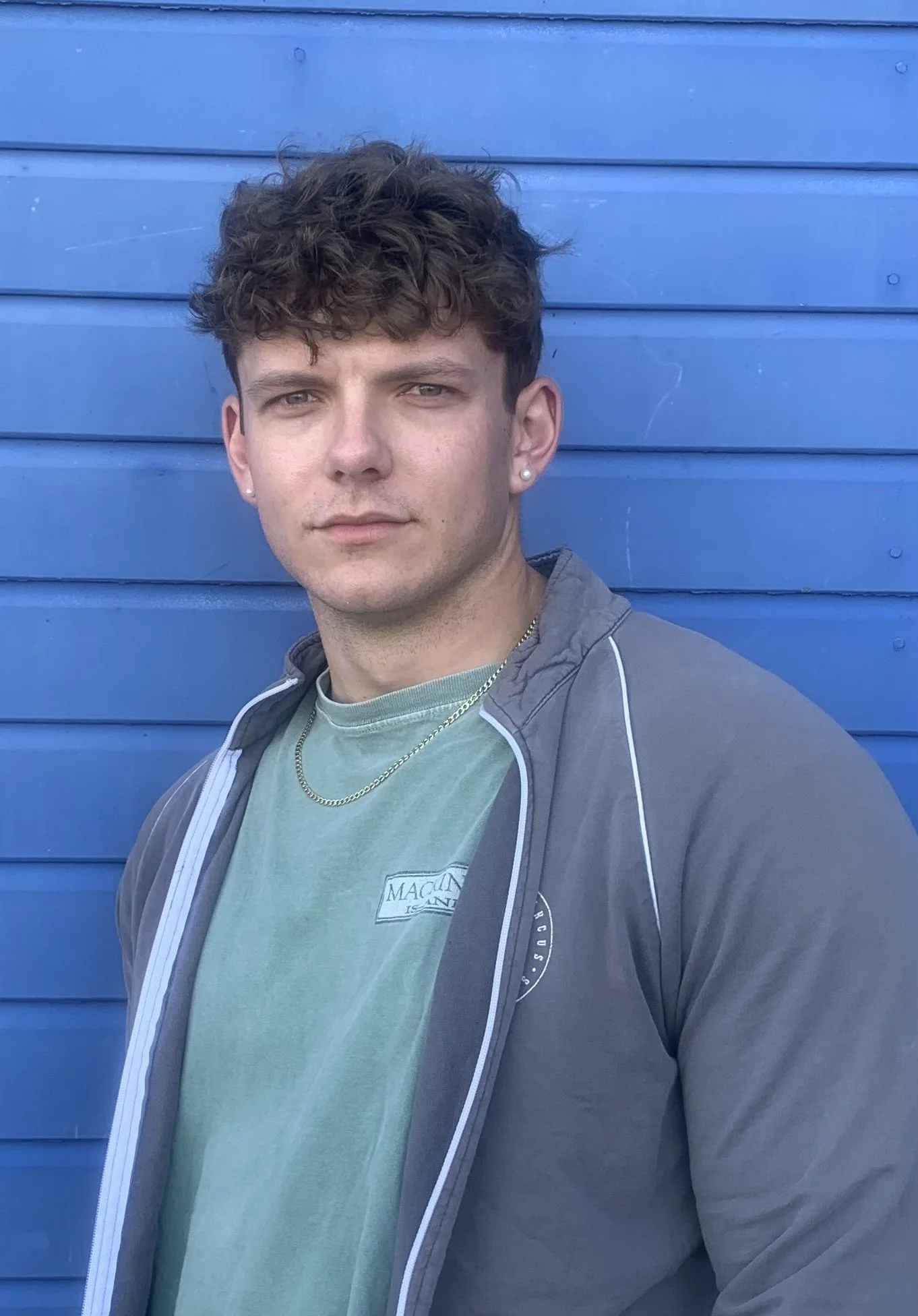 Logo for Santa Monica Trapese featuring a whale jumping out of the water with a mountain in the background, with sun rays behind it.