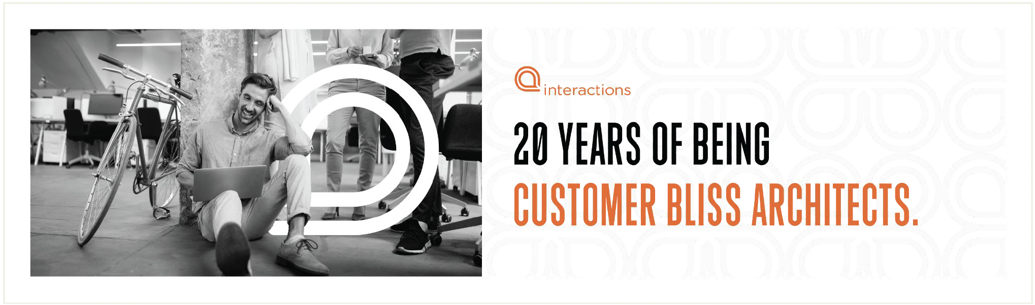 A man sitting on the floor with a laptop, bicycle beside him, and a large white logo in the background at an office or coworking space. Overlaid text reads '20 Years of Being Customer Bliss Architects' for Interactions.