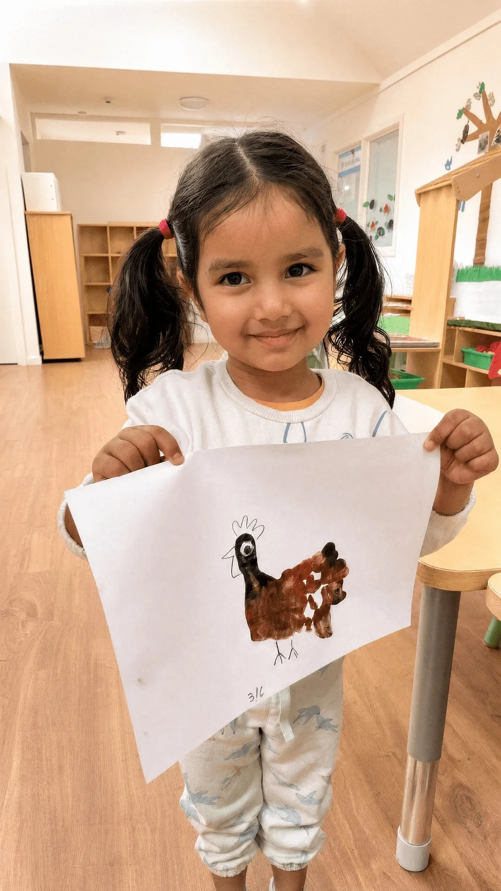 Smiling child holding up their artwork