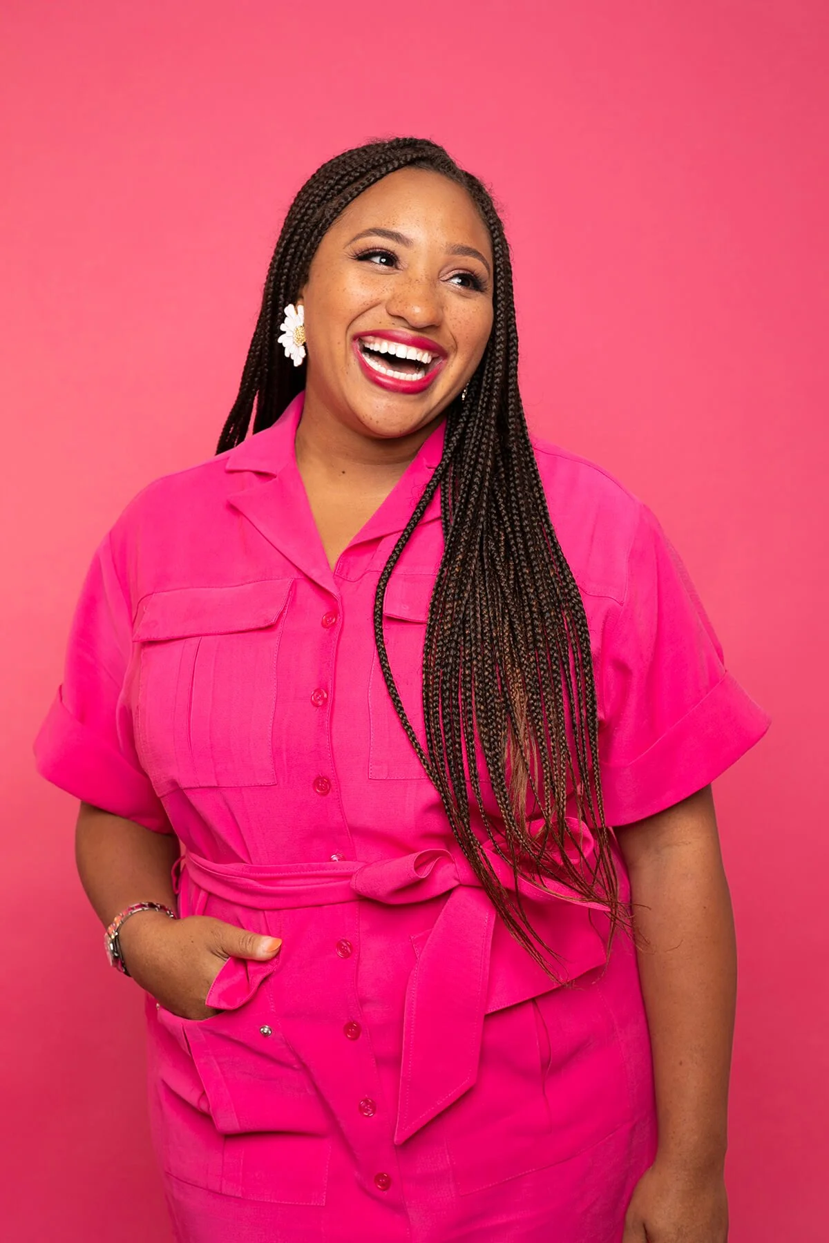 Smiling person in pink dress against pink background