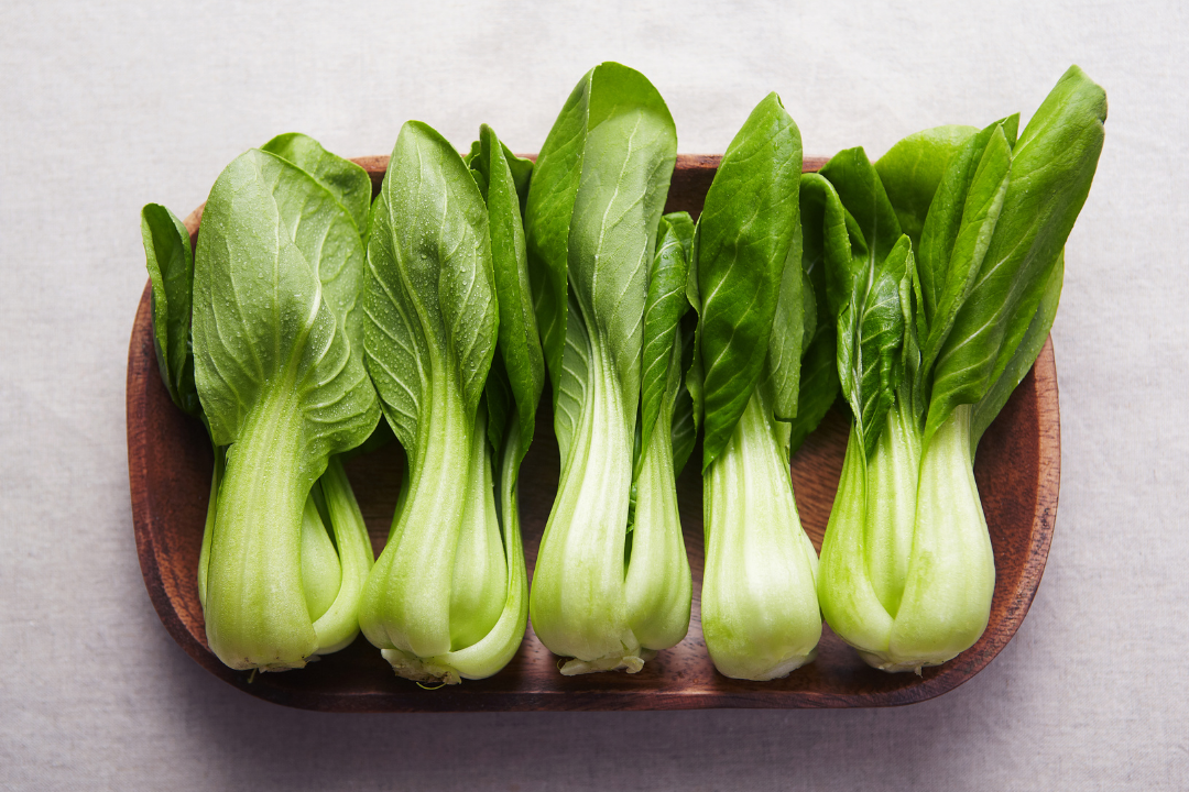 Fresh bok choy arranged in a wooden dish