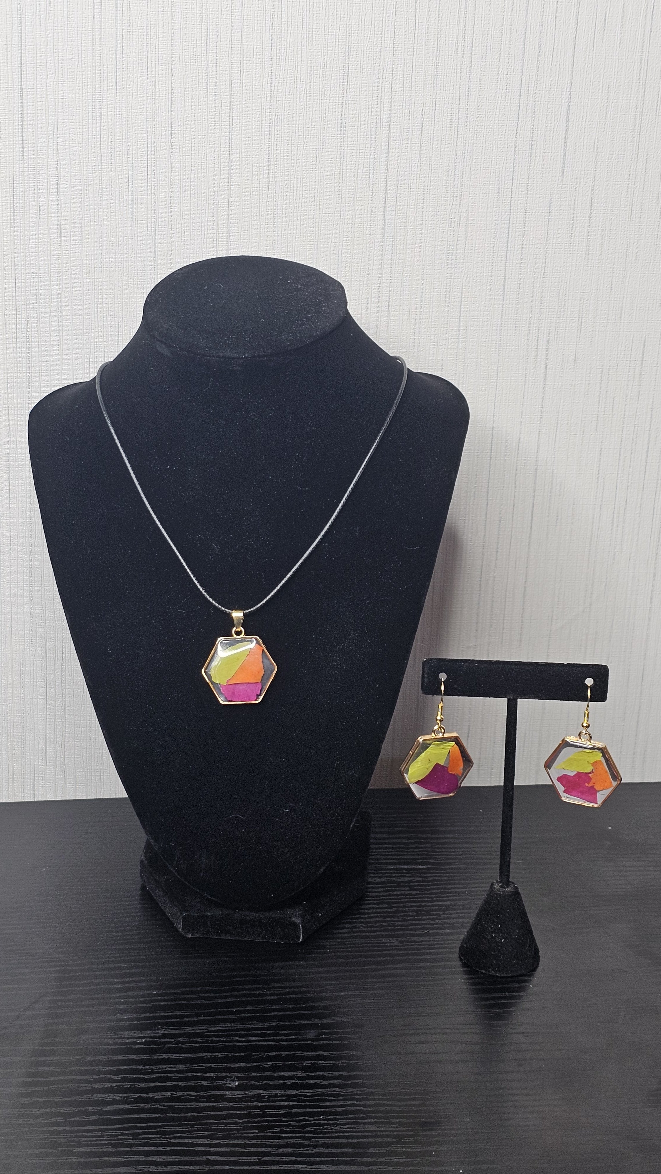 Pendant and matching earrings. Hexagon shaped with gold metal surrounding the petals from their bouquet.