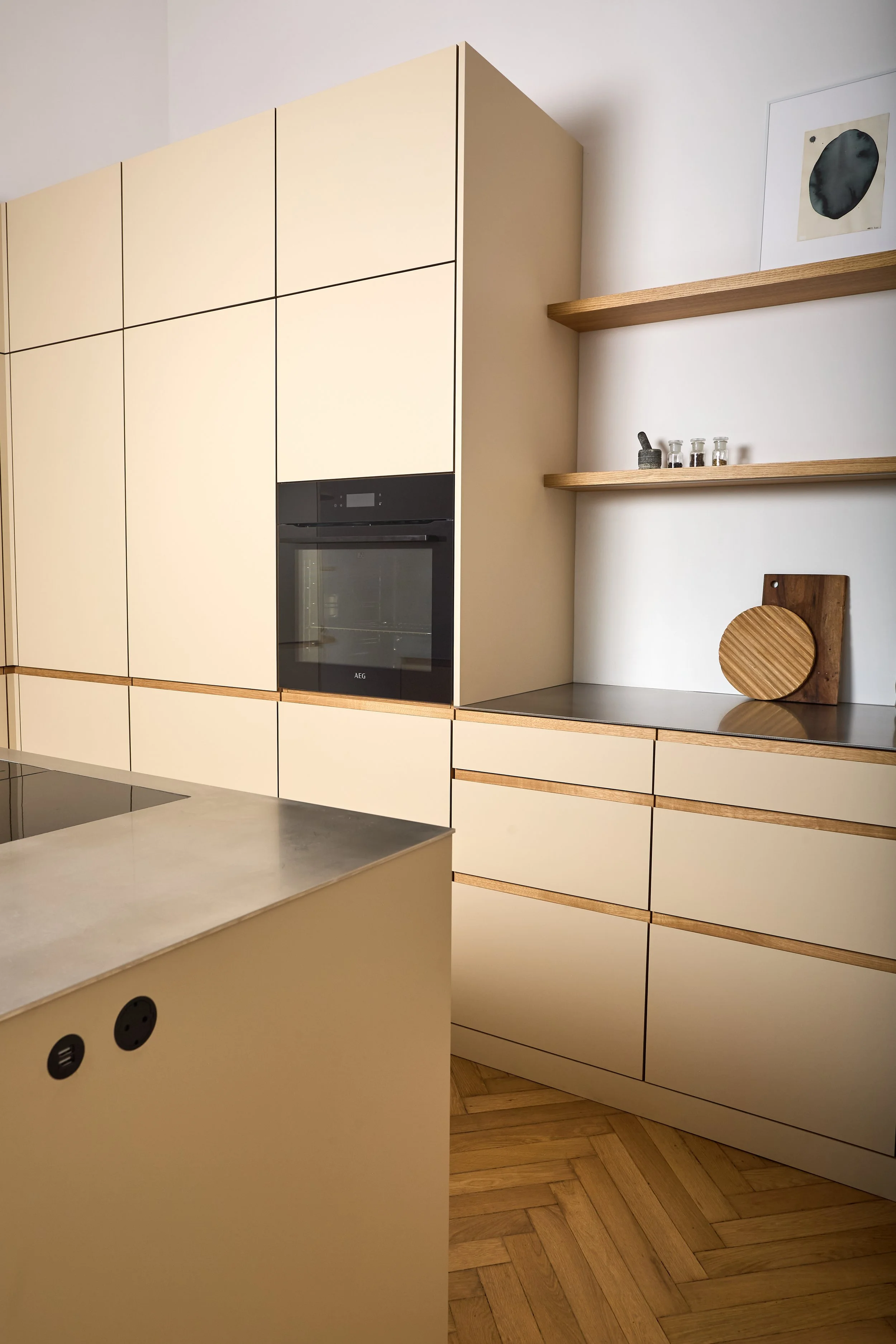 Moderne Küche mit beige Schränken, Holzregalen und Holzboden, inklusive integrierter Backofen.