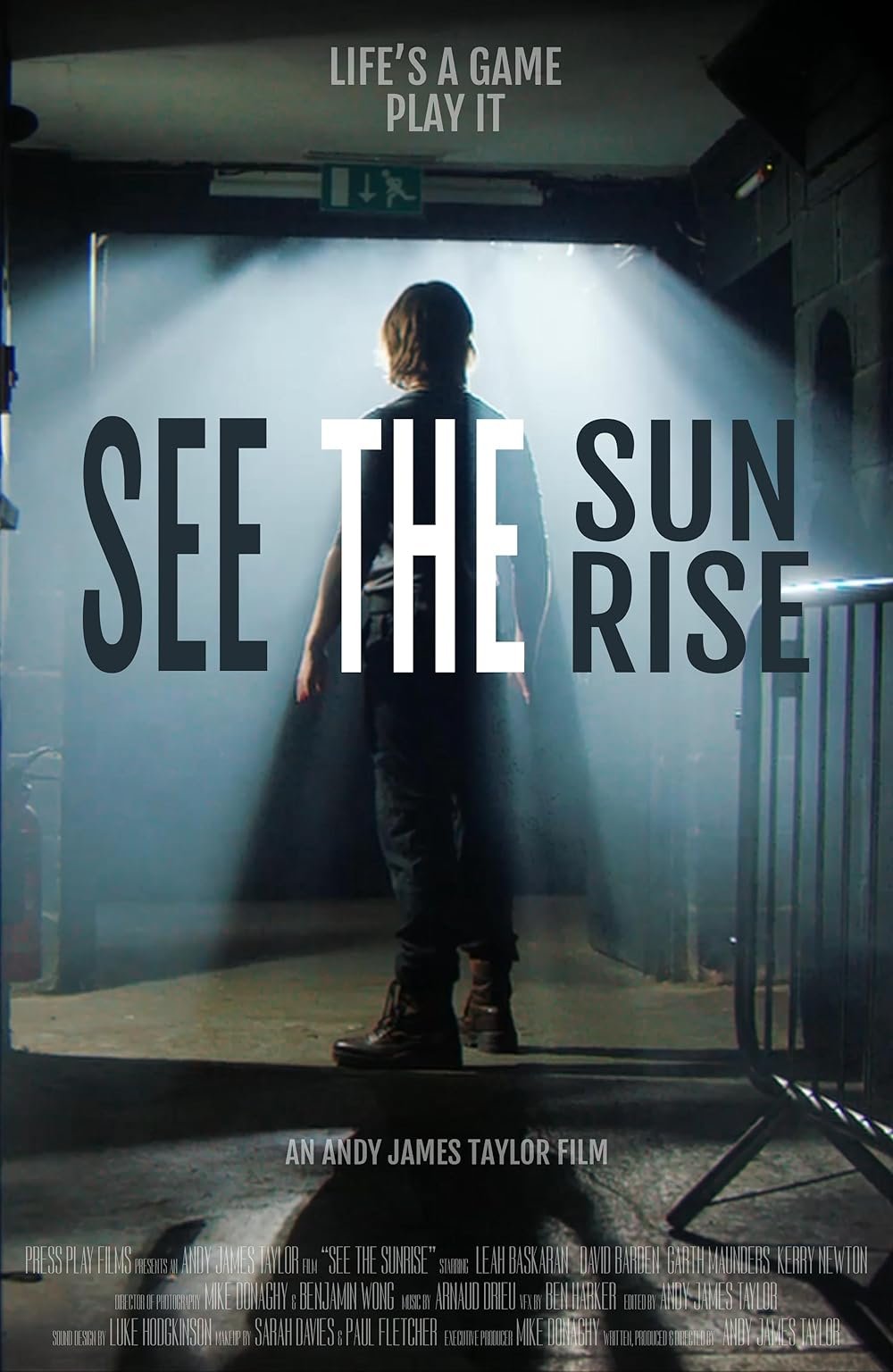 A person standing in an entrance with bright light shining behind them, with overlaid text that reads "Life's a game, play it," "See the sunrise," and "An Andy James Taylor film."
