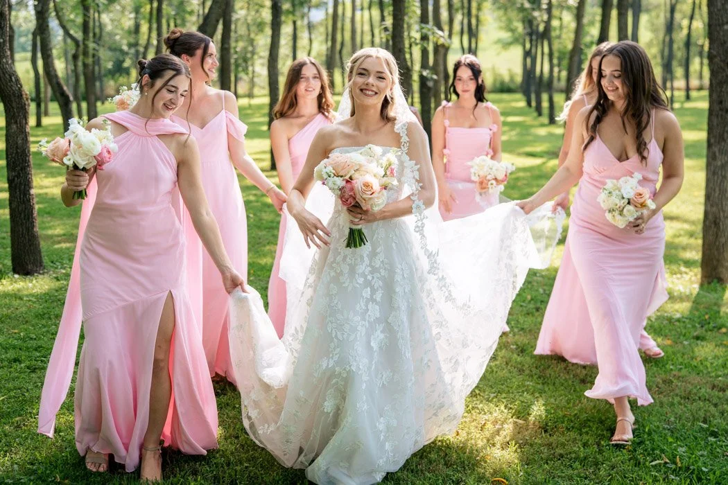 Bride walking with bridesmaids in pink dresses at a Northern Virginia wedding.`