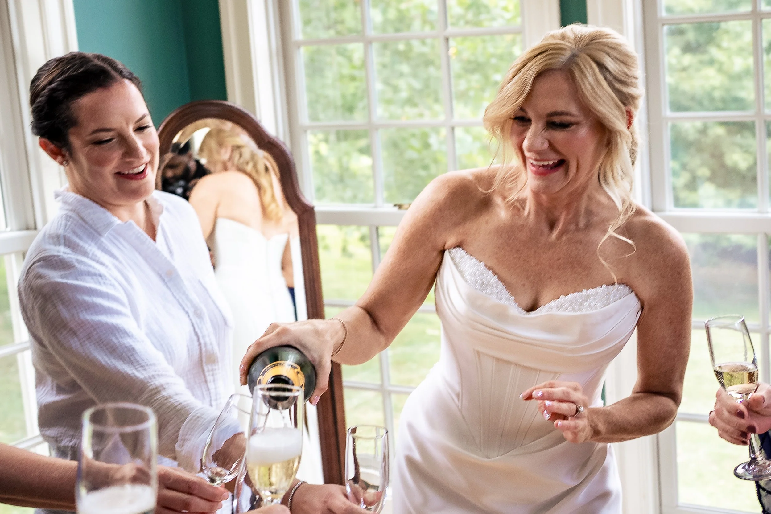 bride pouring champagne into flutes