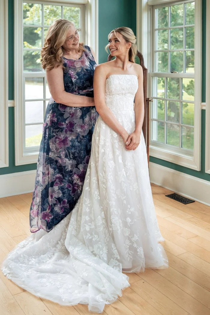 Fiona and her mother sharing a smile after the bride put on her wedding dress.`